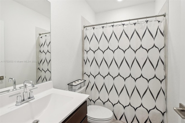 full bathroom featuring a shower with shower curtain, vanity, and toilet