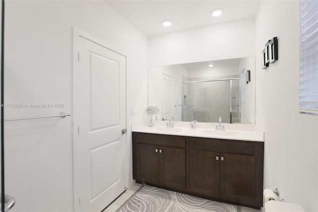 full bathroom with double vanity, recessed lighting, a sink, and a shower stall