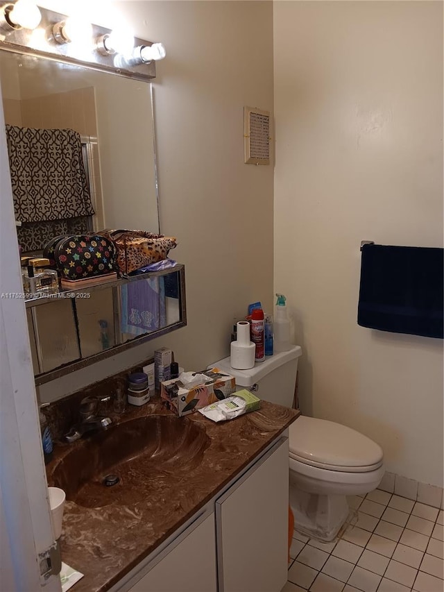 bathroom featuring toilet, tile patterned flooring, and vanity