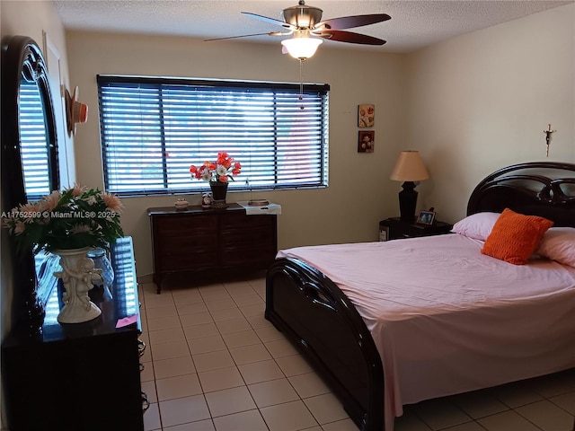 bedroom with a ceiling fan, a textured ceiling, and light tile patterned floors