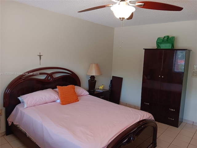 bedroom with a textured ceiling, light tile patterned floors, and a ceiling fan