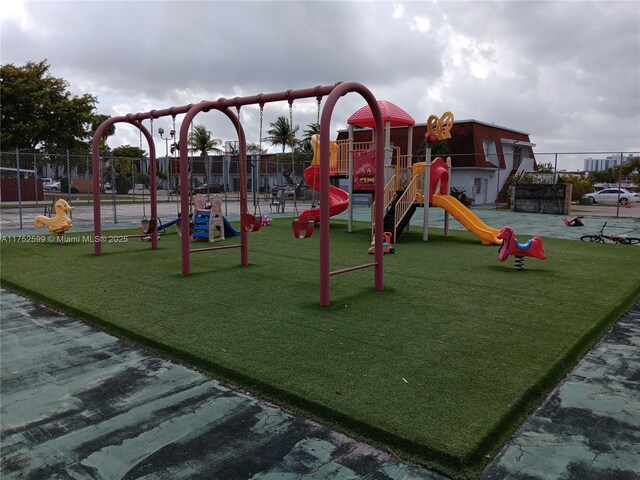 community play area with fence and a lawn