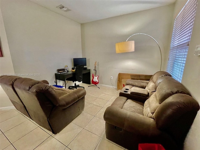 living area featuring light tile patterned floors, baseboards, and visible vents