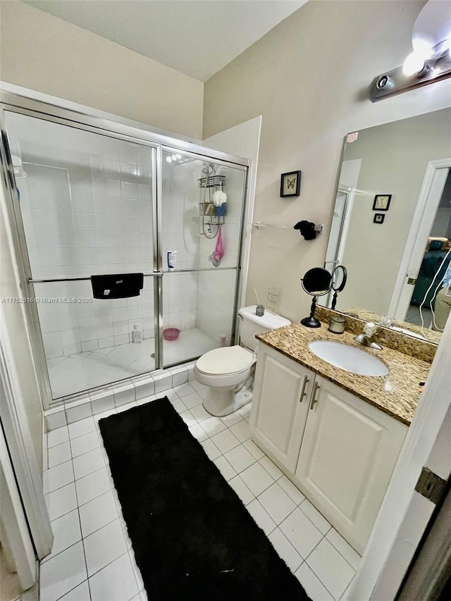 full bath featuring a stall shower, vanity, toilet, and tile patterned floors