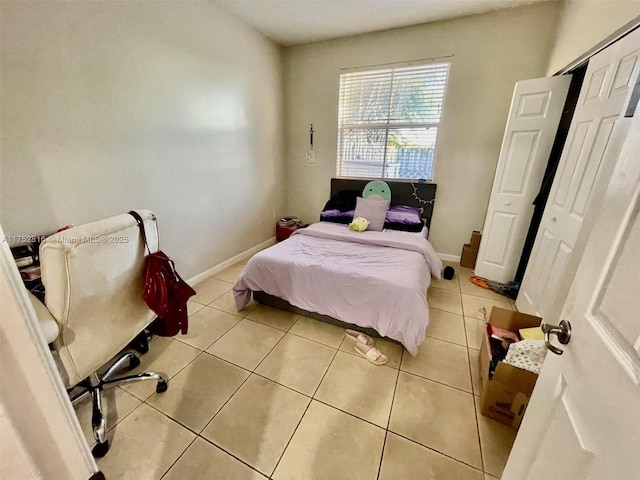 bedroom featuring light tile patterned floors and baseboards