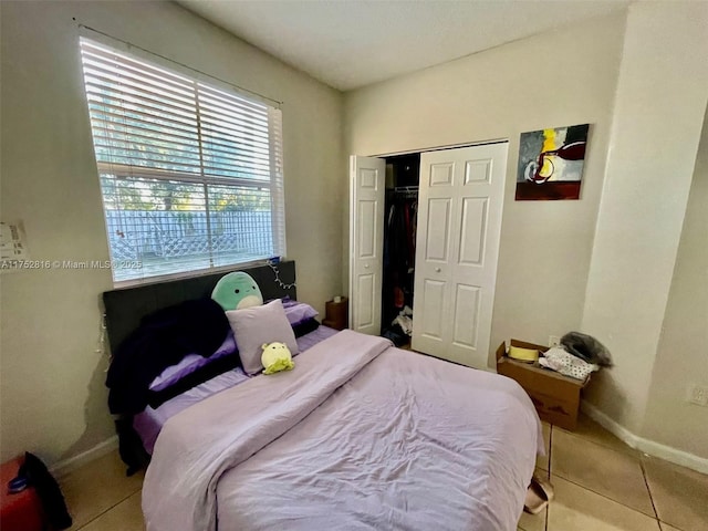 bedroom featuring a closet, baseboards, and tile patterned floors