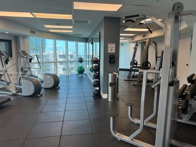 gym featuring a paneled ceiling and visible vents