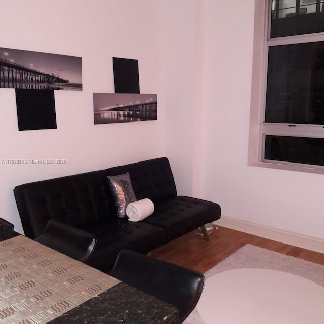 living area with baseboards and wood finished floors