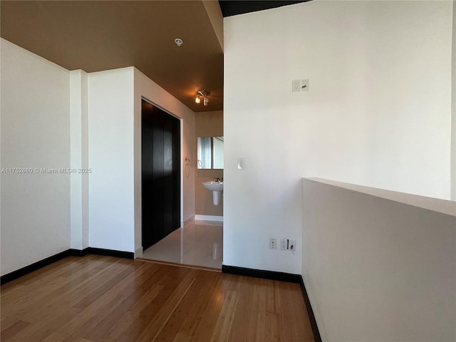 hallway with baseboards and wood finished floors