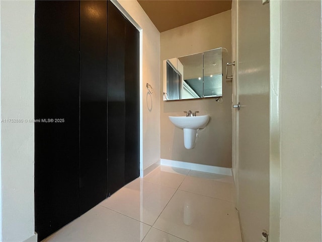 bathroom featuring a sink, baseboards, and tile patterned floors