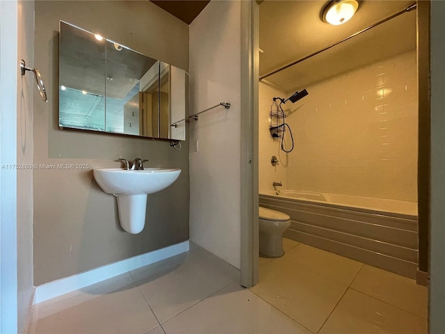 bathroom featuring toilet, tile patterned flooring, baseboards, and shower / bathing tub combination