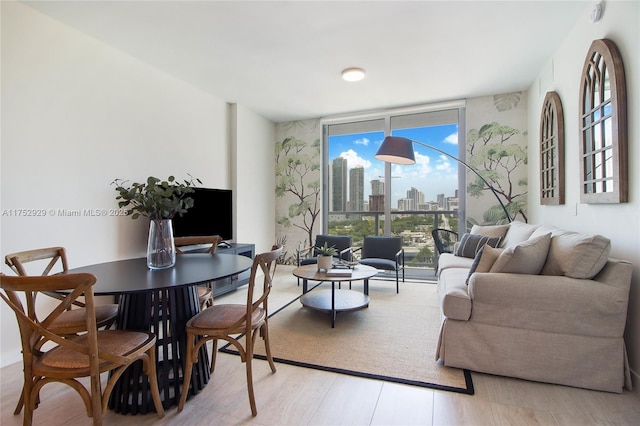 living room with light wood-style floors and floor to ceiling windows