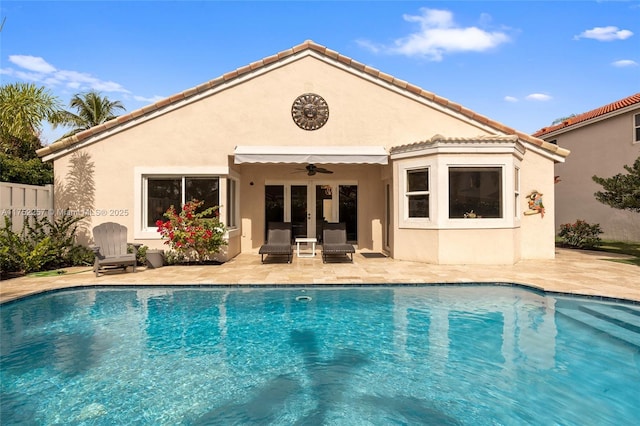 back of house featuring an outdoor pool, ceiling fan, and stucco siding