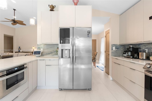 kitchen with light tile patterned floors, ceiling fan, appliances with stainless steel finishes, backsplash, and modern cabinets