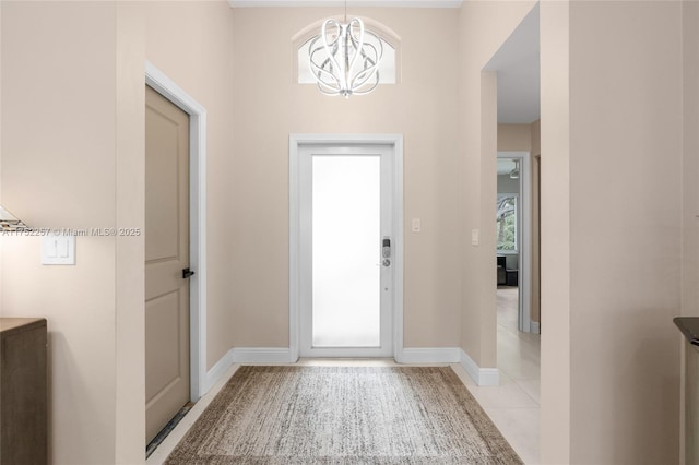 doorway to outside with a chandelier, light tile patterned floors, and baseboards