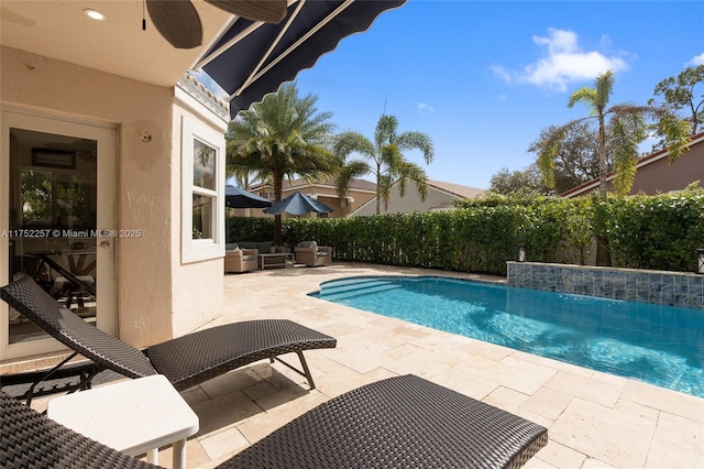 view of swimming pool featuring a patio area, ceiling fan, and a fenced in pool