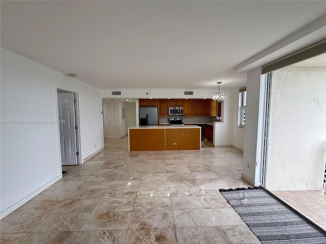 kitchen featuring visible vents, a kitchen island, decorative light fixtures, stainless steel appliances, and light countertops