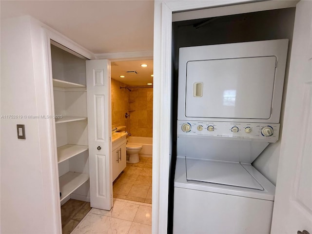 laundry room featuring laundry area, light tile patterned flooring, and stacked washer and clothes dryer