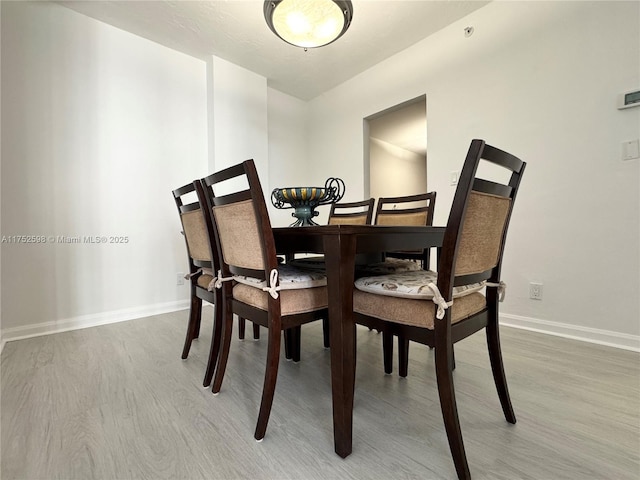 dining space featuring baseboards and wood finished floors