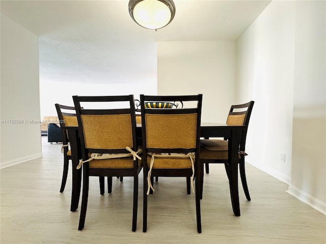 dining area featuring light wood finished floors and baseboards