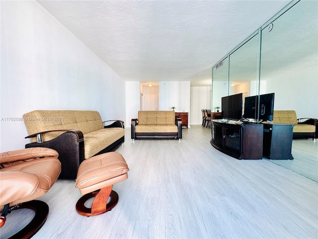 living area with a textured ceiling and wood finished floors