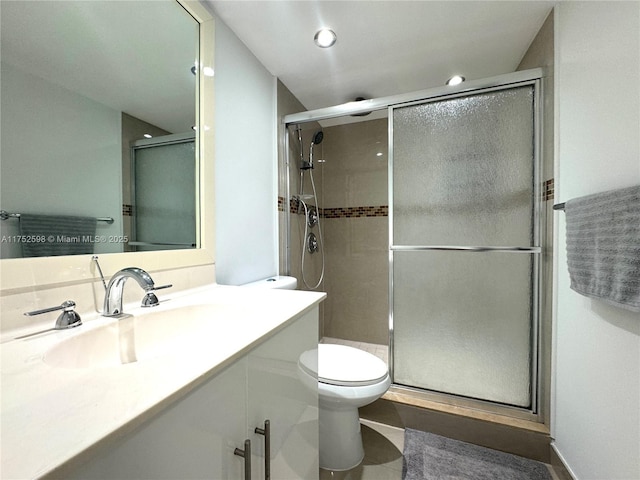 bathroom with recessed lighting, toilet, a shower stall, vanity, and tile patterned flooring