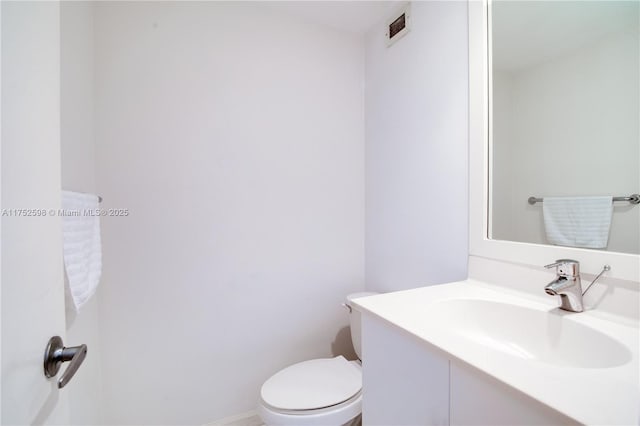 bathroom featuring visible vents, vanity, toilet, and baseboards