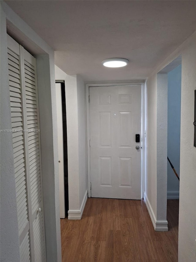 hall with baseboards and wood finished floors