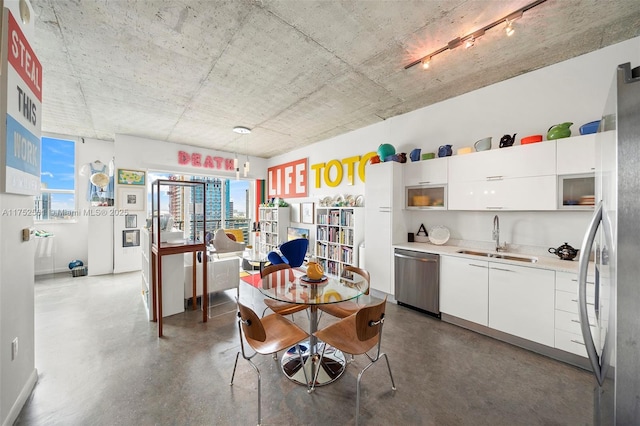 dining space with finished concrete flooring, a view of city, and rail lighting