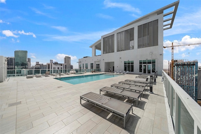 community pool with a patio area and a view of city