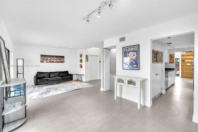 living area with rail lighting, baseboards, and visible vents