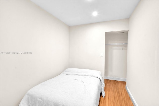 bedroom featuring a closet, baseboards, and wood finished floors