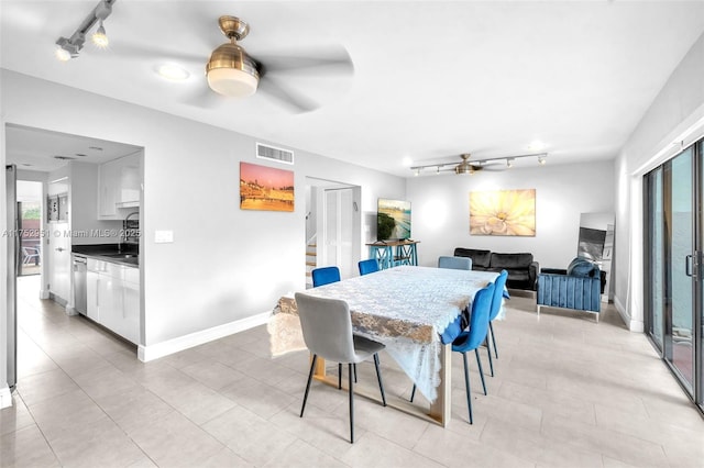 dining area featuring visible vents, baseboards, ceiling fan, stairway, and rail lighting