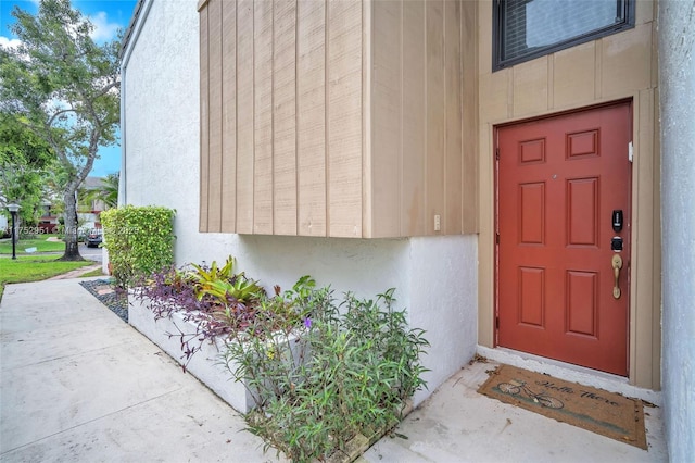 doorway to property featuring stucco siding