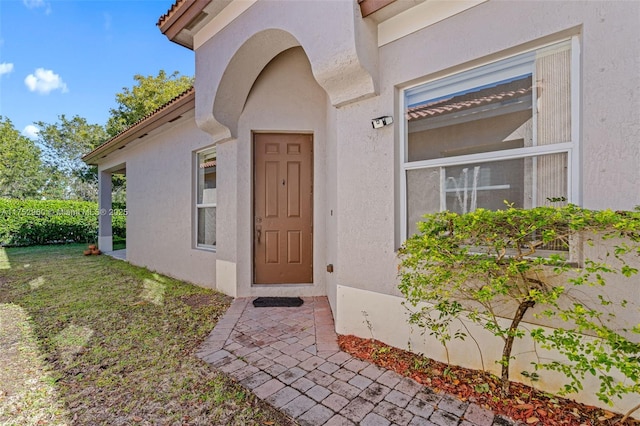 view of exterior entry featuring stucco siding