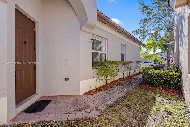 property entrance featuring stucco siding and a tiled roof