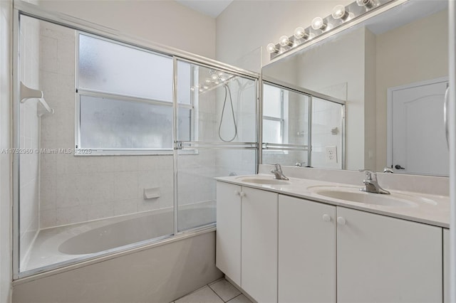 full bath with tile patterned flooring, shower / bath combination with glass door, a sink, and double vanity