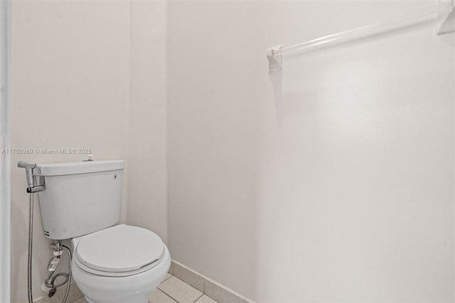 bathroom with baseboards, toilet, and tile patterned floors