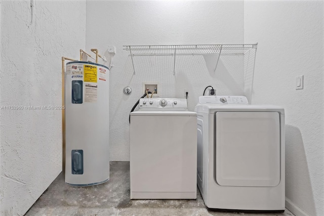 laundry area featuring laundry area, water heater, washer and dryer, and a textured wall