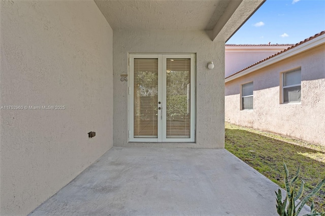 doorway to property featuring a patio area, french doors, and stucco siding