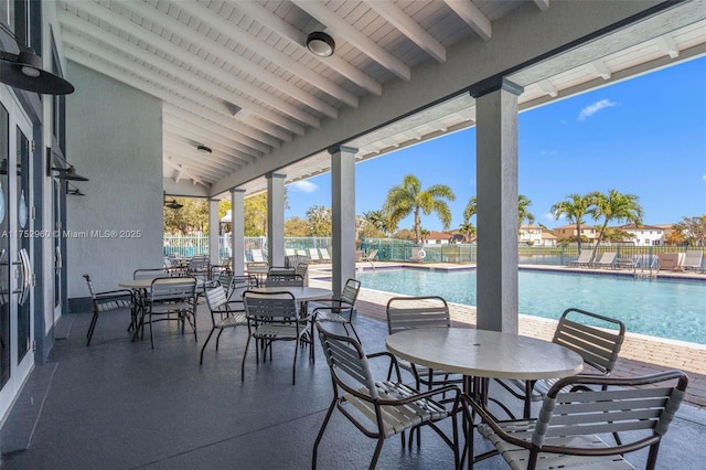 view of patio / terrace featuring fence and a community pool