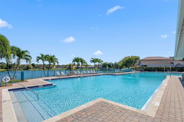 community pool with fence and a patio