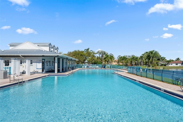 community pool with a patio area and fence