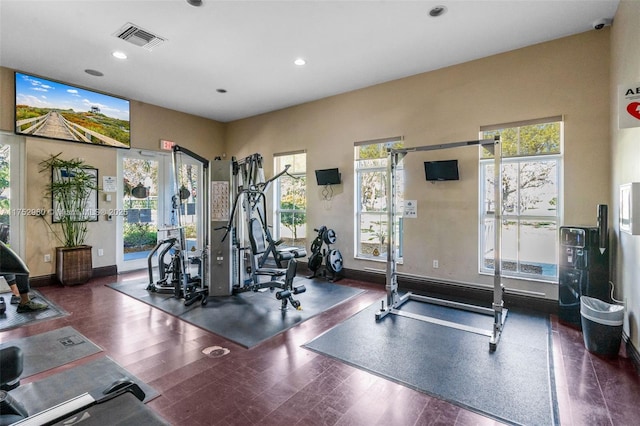 exercise room with baseboards, visible vents, wood finished floors, and recessed lighting