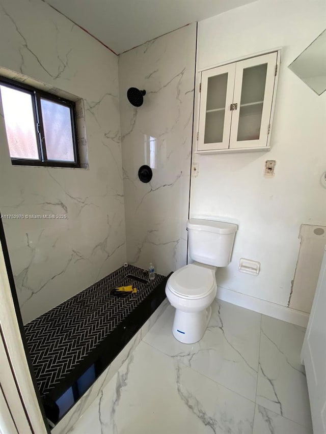 full bathroom with marble finish floor, a marble finish shower, toilet, and baseboards