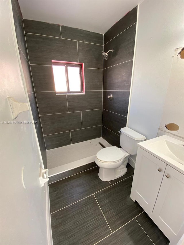 full bathroom featuring toilet, a shower stall, and vanity