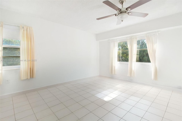 empty room featuring ceiling fan, baseboards, and light tile patterned flooring