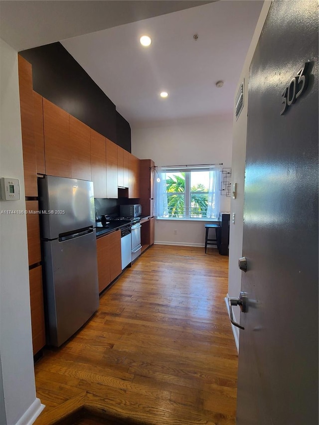 kitchen featuring visible vents, light wood-style floors, appliances with stainless steel finishes, dark countertops, and modern cabinets