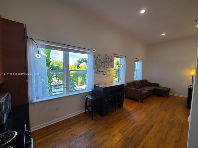 living room with baseboards, wood finished floors, and recessed lighting