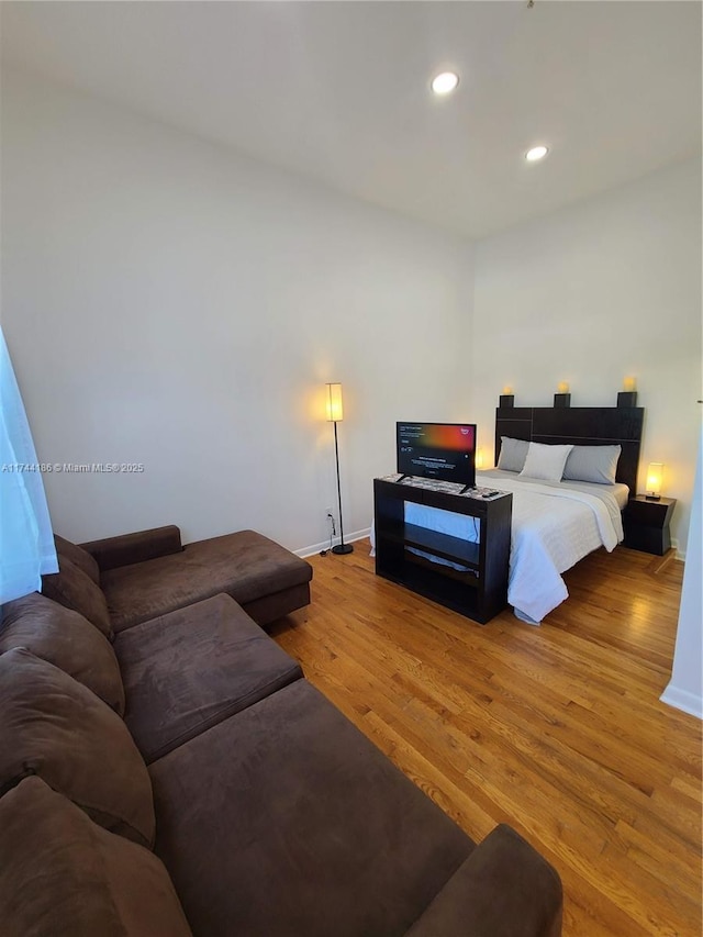 bedroom featuring baseboards, wood finished floors, and recessed lighting